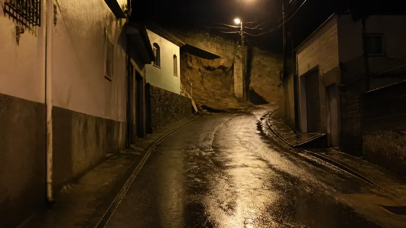 Carro atinge muro e fica pendurado em telhado de casa em Sabará